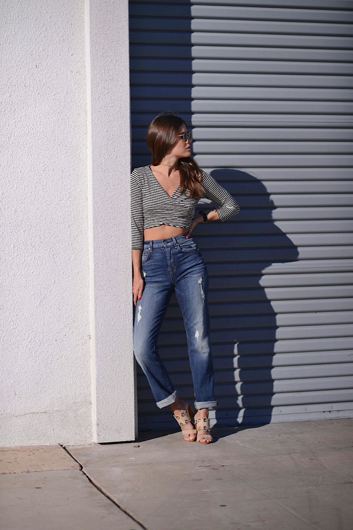 Woman leaning against a wall, with a shadow.