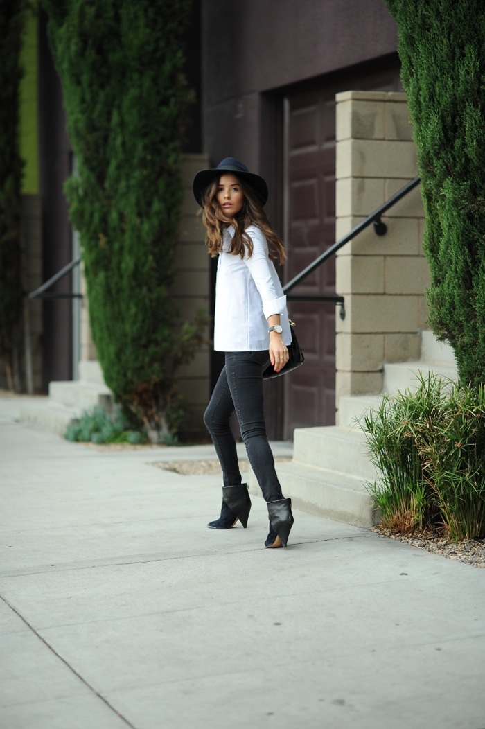 blank itinerary wearing black jeans, white blouse and a navy blue hat