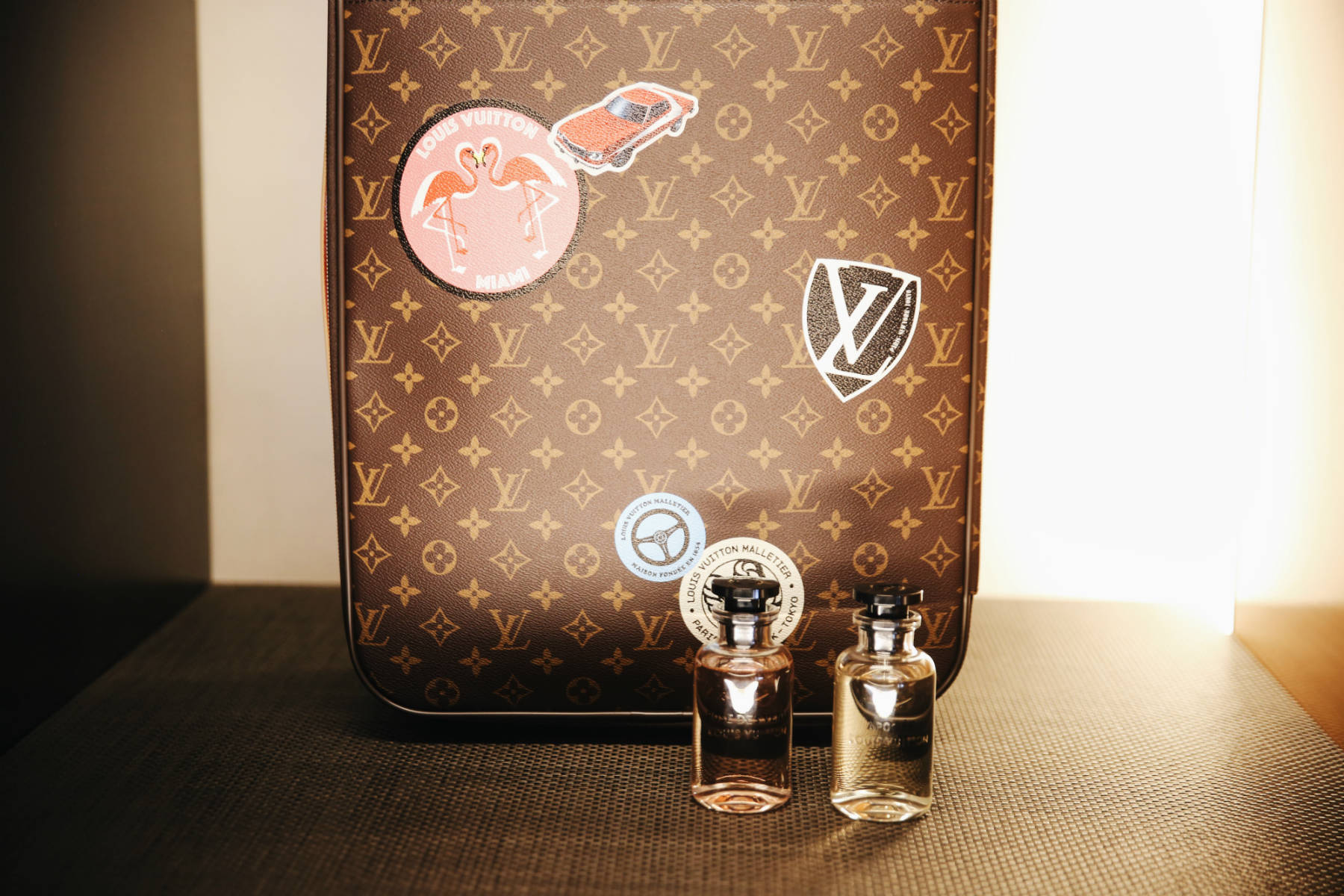 Louis Vuitton monogram suitcase and perfume bottle.