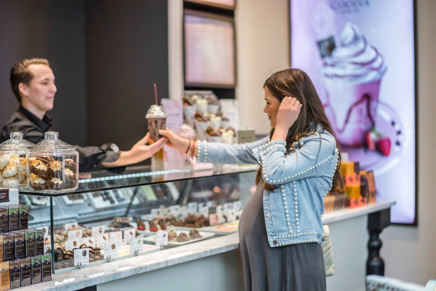 girl ordering inside a godiva chocolatier store